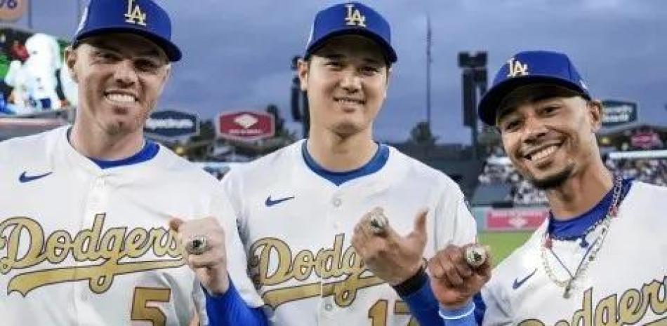 Freddie Freeman, Shohei Ohtani y Mookie Betts exhiben sus anillos de campeones mundiales de las Grandes Ligas en 2024.