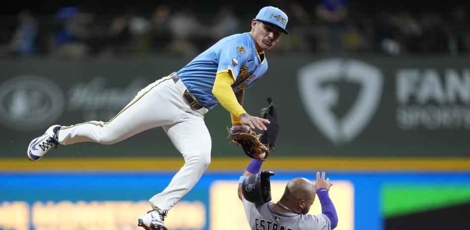 Joey Ortiz, izquierda, de los Cerveceros, pone fuera a Thairo Estrada, de los Rockies, en un intento de robo durante la séptima entrada del juego de béisbol de Grandes Ligas, el viernes 27 de junio de 2025