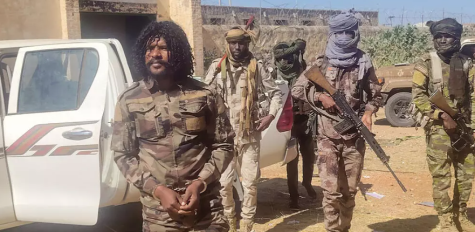 Fotografía difundida por las Fuerzas de Apoyo Rápido (FAR) el 30 de octubre de 2025 en la que se ve a las FSR deteniendo a un combatiente conocido como Abu Lou Lou (a la izquierda) en El Fasher, en la región de Darfur, al oeste de Sudán.