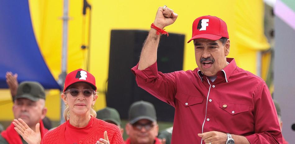 El presidente venezolano, Nicolás Maduro, levanta el puño junto a su esposa Cilia Flores durante un mitin para conmemorar el 33 aniversario del fallido golpe militar de 1992 del fallecido presidente Hugo Chávez contra el gobierno (1989-1993) de Carlos Andrés Pérez en Caracas el 4 de febrero de 2025.