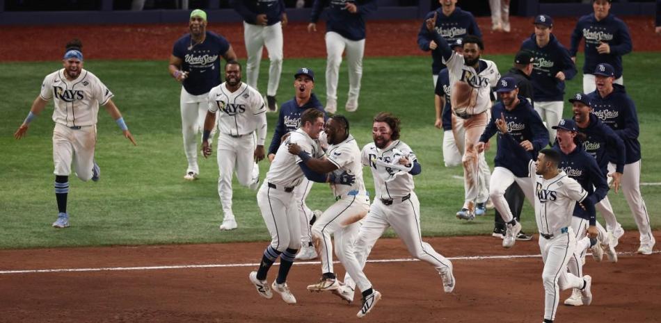 Peloteros de los Rays de Tampa festejan en el medio del terreno luego de venir de atras y vencer a los Cerveceros de Milwaukee.
