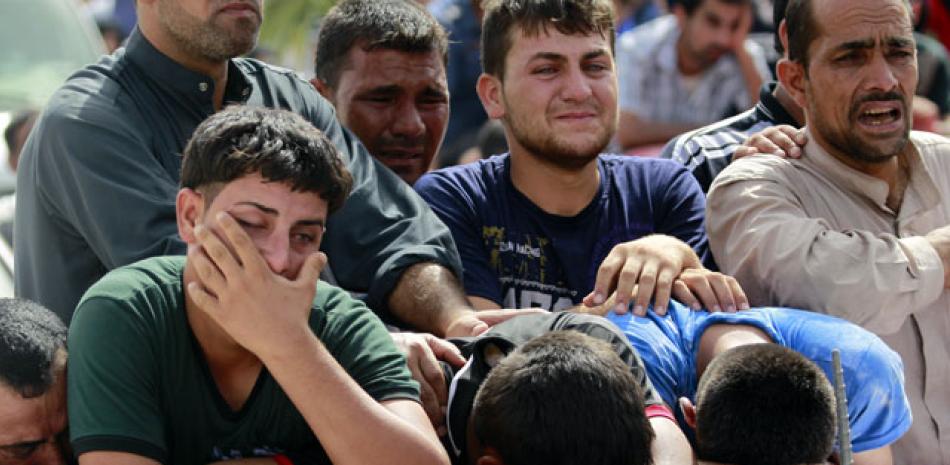 Funeral. Familiares lloran ayer durante el funeral de miembros de fuerzas de seguridad iraquíes que murieron durante un ataque del Ejército Islámico en una estación policial al norte de Bagdad, antier. 37 personas murieron en el ataque.