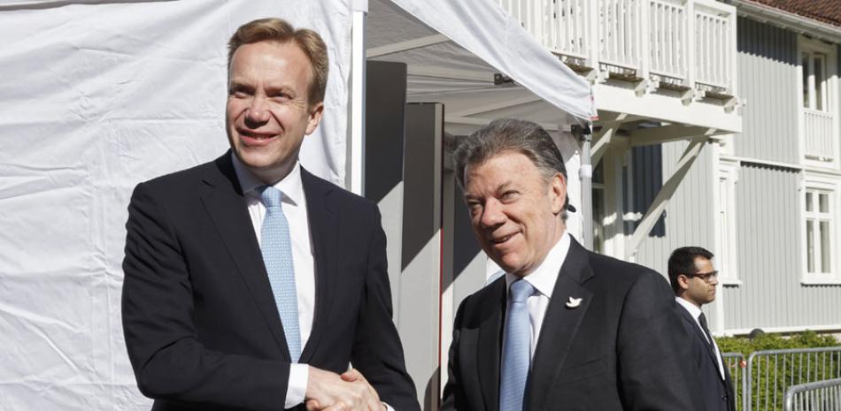 El ministro de Asuntos Exteriores de Noruega, Boerge Brende (izda), saluda al presidente colombiano Juan Manuel Santos, durante la inauguración del Forum de Oslo, Noruega, el 16 de junio del 2015. EFE
