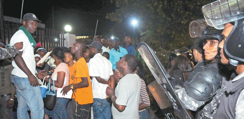 Custodia. Agentes de la Policía Nacional montaban guardia en las afueras del Ministerio de Interior y Policía, mientras los haitianos que no pudieron inscribirse en el Plan de Regularización se quejaban del proceso.