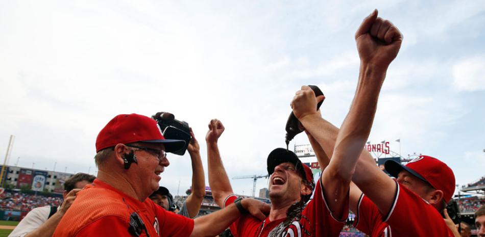 El lanzador Max Scherzer es bañado con mermelada de chocolate por Jordan Zimmerman luego de lanzar un partido sin hit ni carreras ante los Piratas de Pittsburgh.