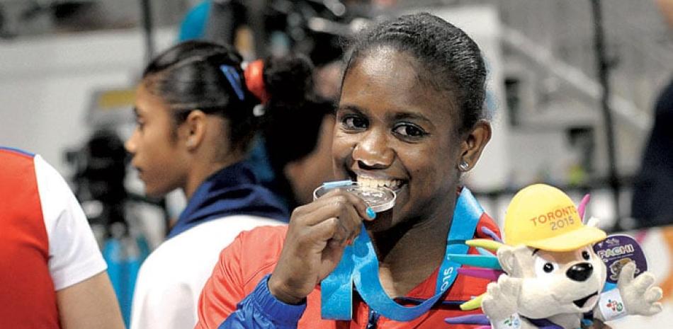 Felicidad. La gimnasta dominicana Yamilet Peña muerde la inédita presea de plata que obtuvo este martes en los Juegos Panamericanos de Toronto, Canadá.