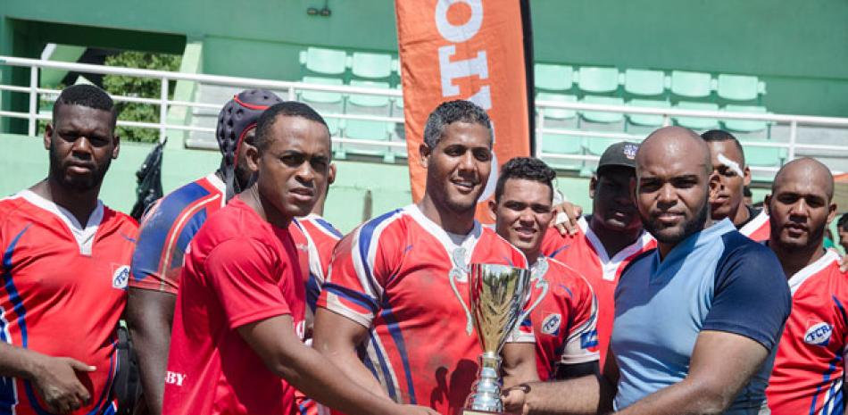 Víctor Silverio y Cristían Lorenzo entregan la Copa Máximo Gómez al capitán del equipo cubano Dairy Rondón, centro.
