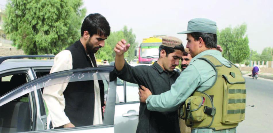 Requisa. Un oficial de seguridad afgano cachea a un hombre en Kandahar, la ciudad natal del mulá Omar, ayer.