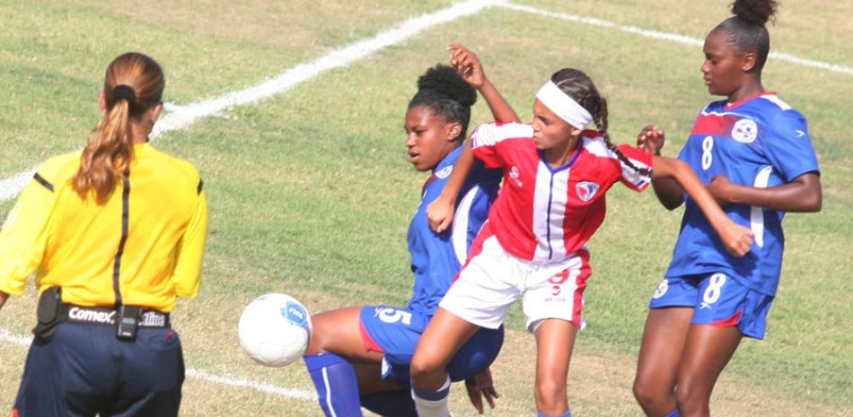 Dos jugadoras de Bermuda tratan de cerrarle el paso a una dominicana durante el partido final entre ambos conjuntos.