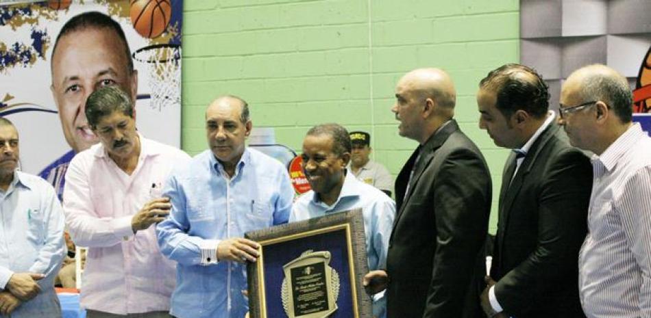 Juan Francisco Caraballo director ejecutivo del INTABACO recibe la placa por la dedicatoria del torneo de baloncesto de Moca al presidente Danilo Medina.