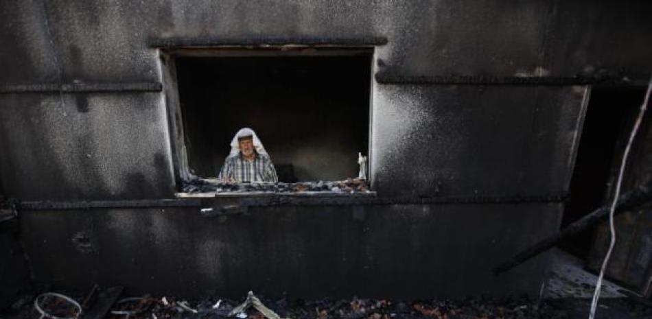 Un hombre palestino inspecciona los restos de una vivienda que fue incendiada en un ataque cometido presuntamente por colonos judíos y en el que murió un bebé palestino de 18 meses. en la localidad de Duma, cerca de Naplusa, en Cisjordania, el 31 de julio de 2015. (Foto AP/Majdi Mohammed).