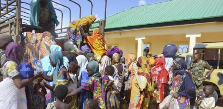 En esta imagen del 31 de julio de 2015, mujeres y niños rescatados por soldados nigerianos de manos de Boko Haram en el noreste del país, llegan a una oficina militar en Maiduguri. (Foto AP/Jossy Ola Archivo).