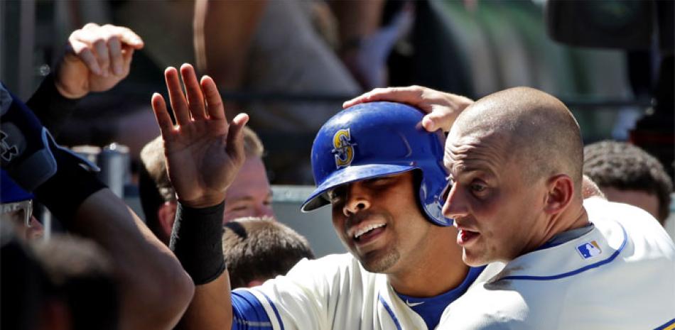 Poder. Nelson Cruz, de Seattle, es felicitado por Kyle Seager (15), y sus compañeros de equipo tras su jonrón en el sexto inning.