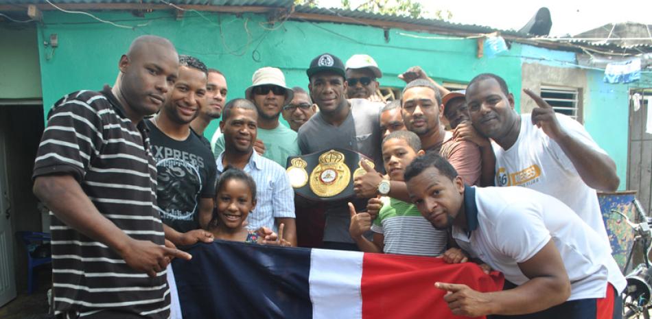 El campeón semicompleto de la Asociación Mundial de Boxeo (AMB), Félix “Mangú” Valera junto a residentes del barrio Villas Agrícolas de la capital.