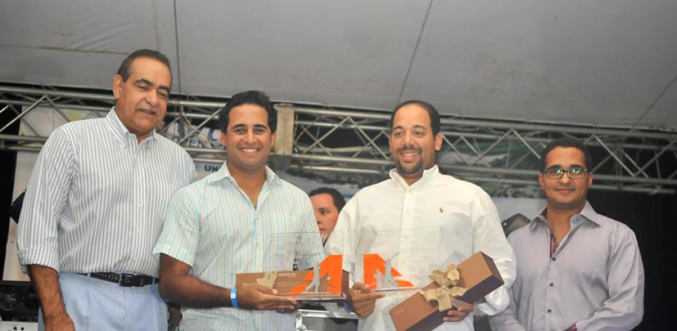 Julio Amado Castaños Guzmán premia a los ganadores del primer lugar, categoría A, José Heredia y Sigfrido Pared.