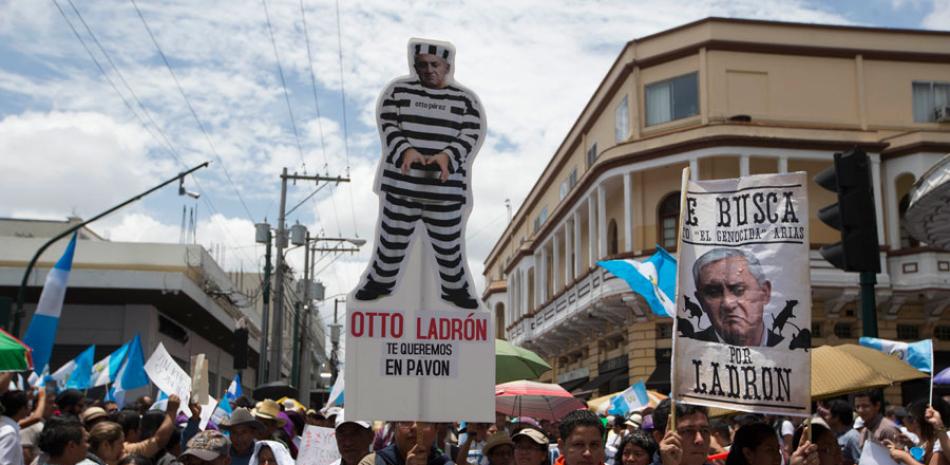 Protesta. Un hombre muestra una imagen del presidente Otto Pérez Molina con traje de prisionero, durante la marcha hacia el Palacio Nacional ayer, en la que se pidió la renuncia del mandatario.