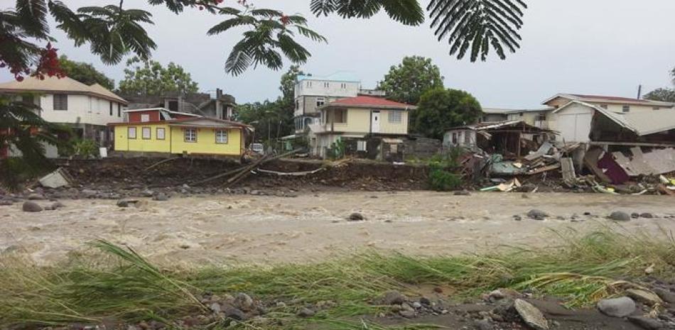 Un río desbordado afecta a algunas de las casas a su paso, debido a la tormenta tropical Erika en Roseau, Dominica, el jueves 27 de agosto de 2015.