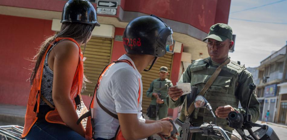 Requisa. Un integrante del ejército venezolano inspecciona a un motociclista en las inmediaciones de la Aduana Principal fronteriza entre Colombia y Venezuela antier, en San Antonio.