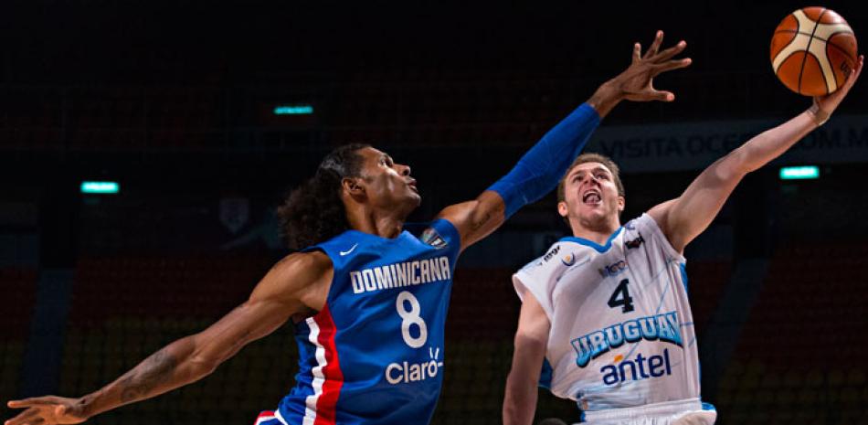Edward Santana, de República Dominicana, trata de bloquear un intento al canasto de Santiago Vidal, de Uruguay, durante el partido de ayer en el torneo preolímpico de baloncesto.
