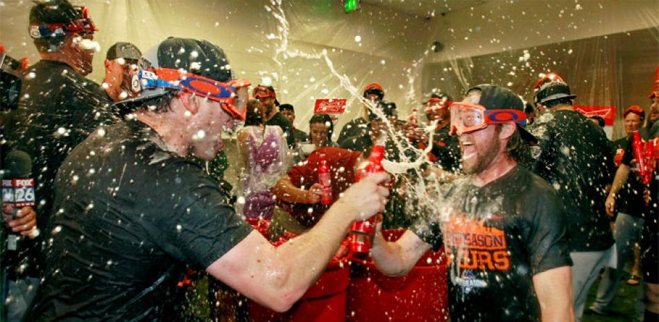 Los jugadores Jed Lowrie, izquierda, y Josh Fields, de los Astros, celebran su boleto a los playoffs.
