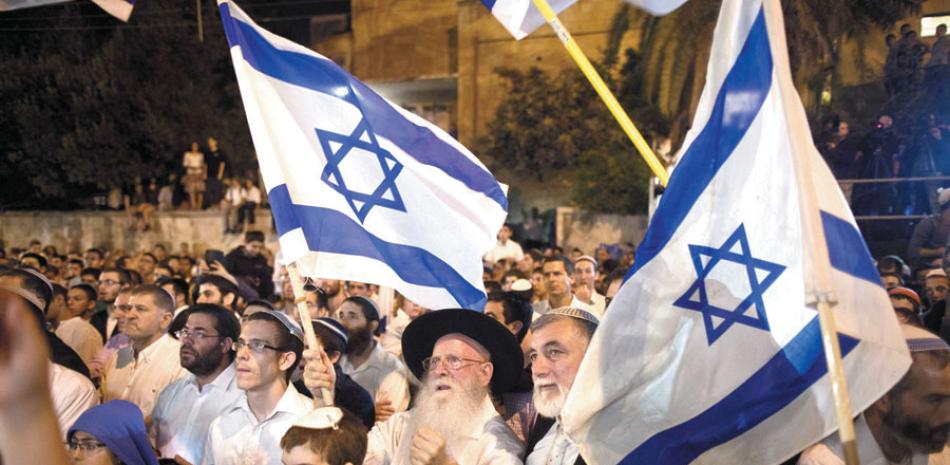 Inseguridad. Manifestantes de derecha israelíes sostiene banderas,durante una protesta frente a la residencia de Benjamín