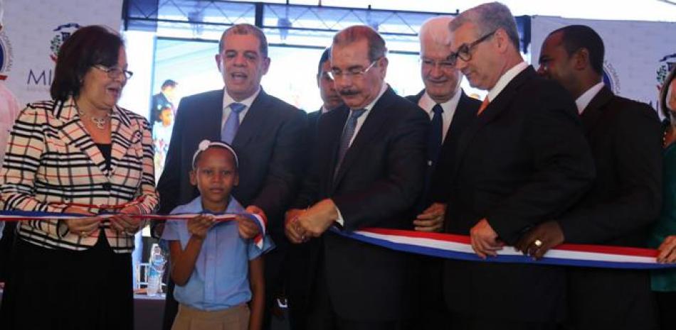 Ceremonia. El presidente Danilo Medina corta la cinta para dejar inauguradas las escuelas básicas El Fundo y Santana, en la provincia Peravia, junto a una estudiante y funcionarios de su gobierno.