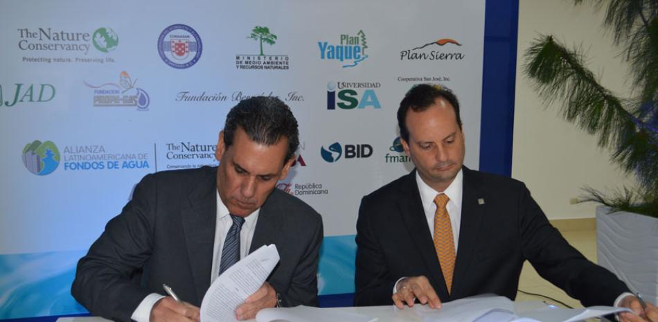 Aquiles Bermúdez, presidente del Fondo Agua Yaque del Norte y Francisco Núñez, de The Nature Conservancy, firman el convenio.