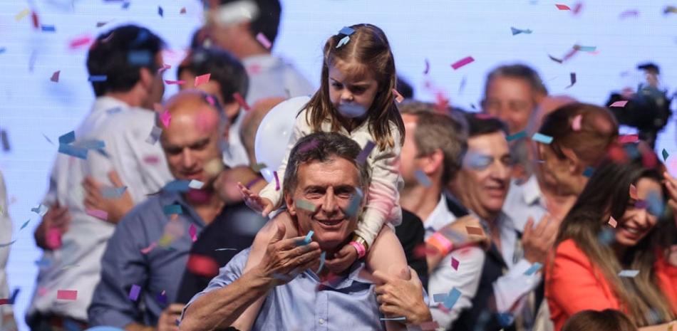 Acto. El candidato Mauricio Macri sostiene a su hija Antonia durante la celebración de su victoria.