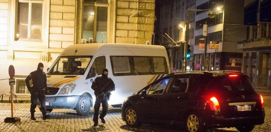 Seguridad. Policías belgas realizan un operativo en un barrio de Bruselas, totalmente paralizado por una amenaza terrorista.