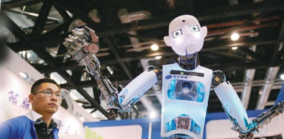 Evento. Varias personas observan un robot expuesto en la Conferencia Mundial de Robots en Pekín.