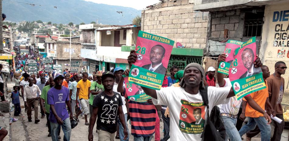 Protesta. Manifestantes haitianos son vistos el miércoles pasado en las calles de Puerto Príncipe, mientras protestan por los resultados de la primera ronda de elecciones del pasado 25 de octubre.