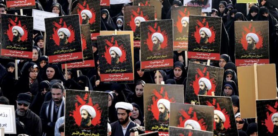 Protesta. Seguidores del clérigo chiíta iraquí Moqtada al-Sar, muestran carteles del clérigo Nimr al- Nimr, durante una manifestación en la ciudad sureña iraquí de Basora, ayer, por la ejecución por Arabia Saudita del religioso Nimr.