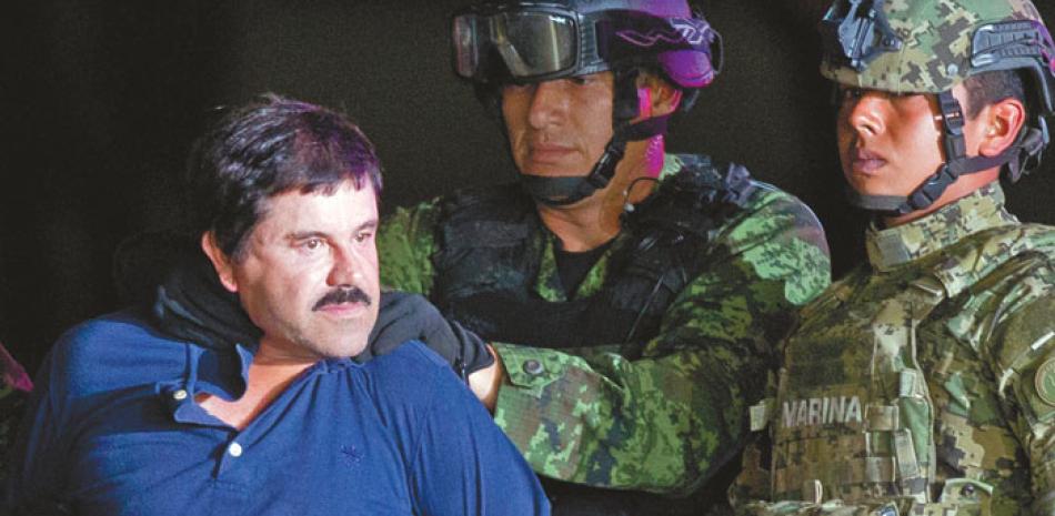 Atrapado. Efectivos del ejército y la marina mexicana obligan al jefe narcotraficante mexicano Joaquín “El Chapo Guzmán” a que voltee hacia la prensa mientras lo conducen esposado hasta un helicóptero, en Ciudad de México, el día de su recaptura.