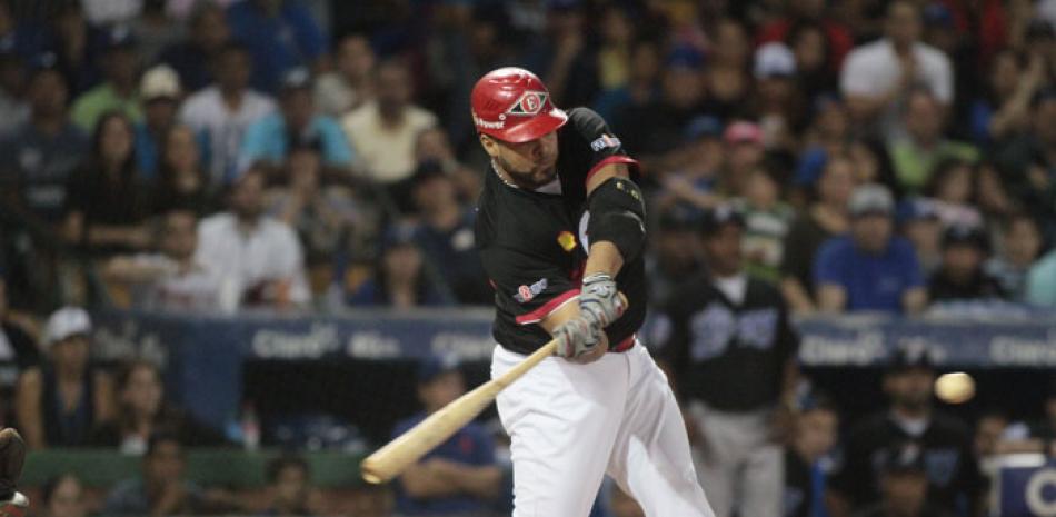 Ronny Paulino, de los Leones del Escogido, al momento de pegar el hit decisivo en el segundo partido de la serie final frente a los Tigres del Licey. El Escogido tomó ventaja de 2-0.