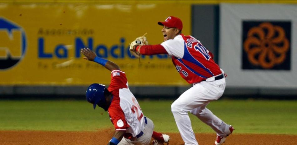 Rubén Sosa de los Cangrejeros de Santurce, de Puerto Rico, es puesto “out” en segunda base por Yulieski Gurriel, de los Tigres de Ciego de Ávila, de Cuba.