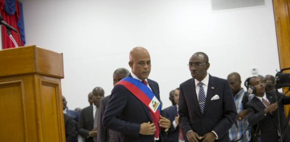 El presidente de Haití, Michel Martelly, habla con el primer ministro, Evans Paul, tras su discurso a legisladores en Puerto Príncipe, Haití.