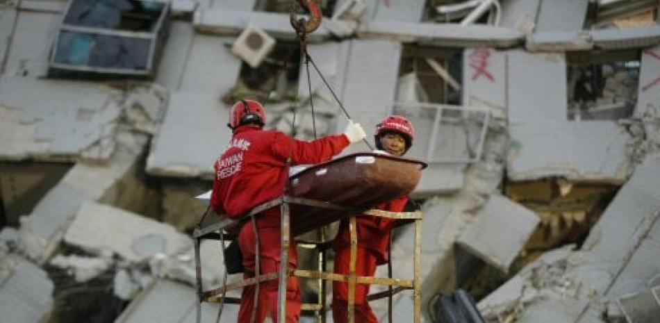Dos socorristas transportan a una víctima retirada de entre los restos de un edificio de apartamentos en Tainan.