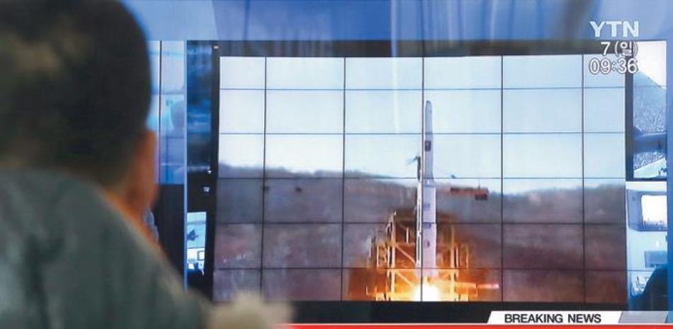 Proyección. Un surcoreano observa un programa de televisión con imágenes de archivo sobre el lanzamiento de un cohete norcoreano, en la estación de tren de Seúl, en Corea del Sur, ayer domingo.