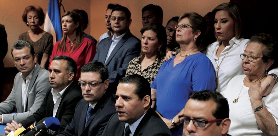 Declaración. El abogado Lisandro Quintanilla (2-d), acompañado de familiares de exmilitares salvadoreños requeridos en España por la matanza de 6 padres jesuitas, ayer en San Salvador.