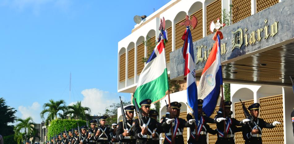 Una escolta de la Policía Nacional desfila portando la Bandera Dominicana y de la institución del orden, durante un desfile realizado en la parte frontal de LISTÍN DIARIO. Varias unidades de la Policía participaron en la vistosa ceremonia realizada en horas de la mañana.