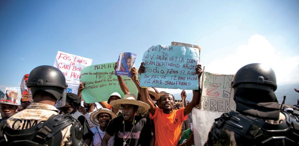 Voces. Seguidores del Partido Lavalás, protestan por las calles de Puerto Príncipe, por los 12 años del derrocamiento de Aristide.