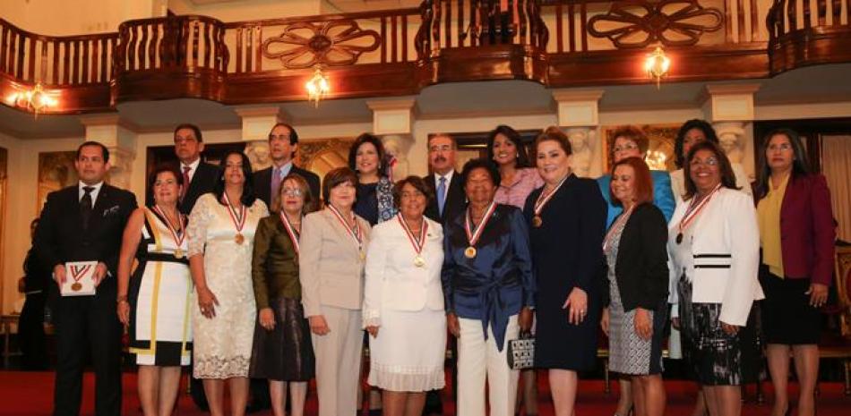 Ceremonia. El presidente Danilo Medina y su esposa, Cándida Montilla, junto a las diez damas que fueron reconocidas ayer con la Medalla al Mérito, de quienes destacó sus aportes a la vida del país.