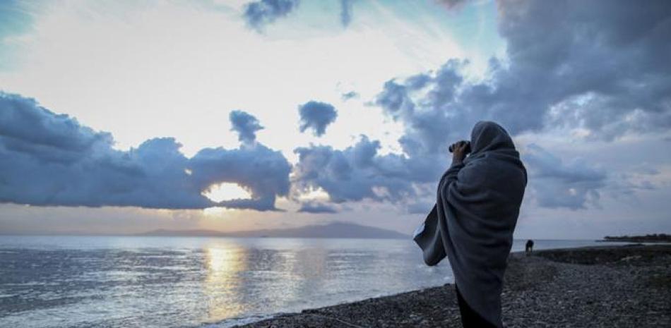 Un voluntario observa el horizonte con prismáticos desde una playa en la isla de Lesbos cerca del puerto de Mytilene (Grecia) hoy, 11 de marzo de 2016. Al menos cinco personas, entre ellas un bebé, fallecieron ayer ahogados mientras intentaban alcanzar la costa griega. EFE