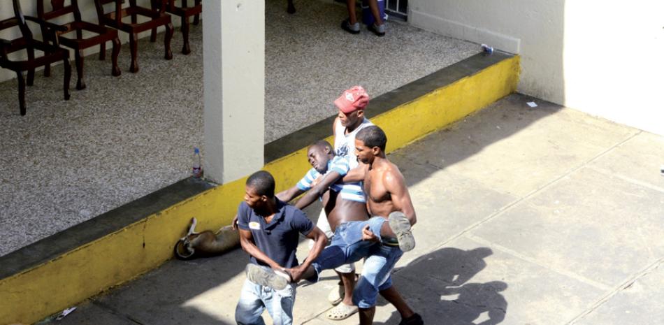 Violencia. Un joven es llevado inconsciente por sus compañeros al área médica, desde uno de los pabellones del penal.