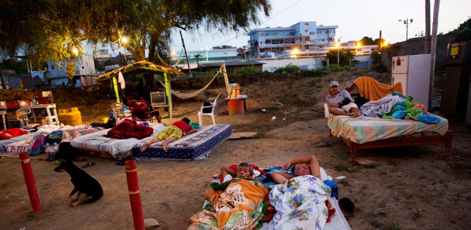 En esta foto del 20 de abril de 2016, los vecinos Carlos Bardales, izquierda, y César Filay, comparten un colchón afuera de sus casas derrumbadas por un terremoto en Manta, Ecuador. AP