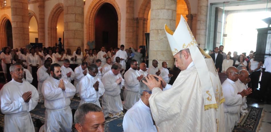 Solemnidad. El obispo auxiliar de la Arquidiócesis de Santo Domingo, Amancio Escapa, impone aus manos a uno de los diáconos que ayer recibió su ordenación.