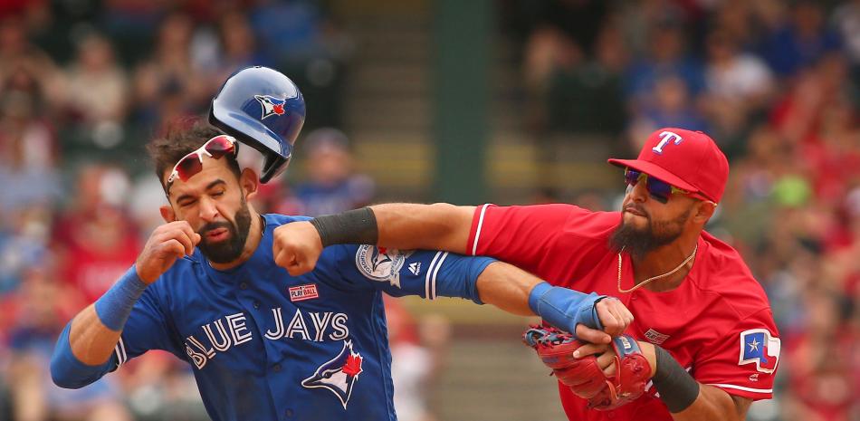 José Bautista, de los Azulejos de Toronto, es golpeado por Rougned Odor, de los Rangers, luego de un deslizamiento del primero en la segunda base durante el octavo inning del partido celebrado ayer en elestadio Globe Life Park en Arlington, Texas ayer.