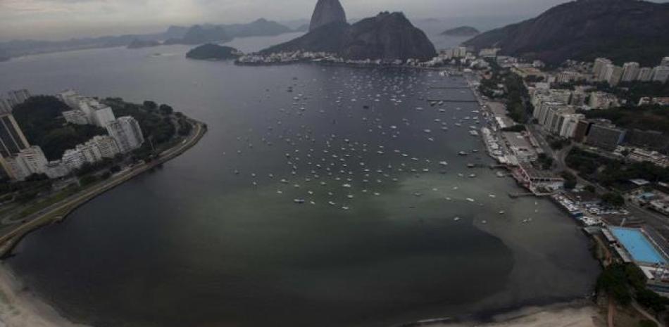 Vista del cerro de Pan de Azúcar (c) junto a una mancha de desagüe en la ensenada de Botafogo, en la Bahía de Guanabara, donde se llevarán a cabo las pruebas de Vela de los Juegos Olímpicos Río 2016. EFE/Marcelo Sayão