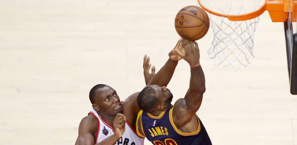 Bymack Biyombo trata de bloquear un lance de LBron James en el segundo cuarto del partido que los Cavaliers le ganaron a los raptors.