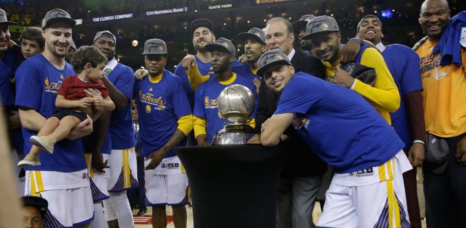 El estelar armador Stephen Curry, el Jugador Más Valioso de la NBA de esta temporada, y sus compañeros figuran junto al trofeo que acredita a los Warriors como campeones de la Conferencia Oeste de la NBA